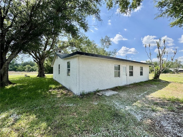 390 Hazel Cir, Punta Gorda, FL 33982 - view of side of home featuring stucco siding and a yard