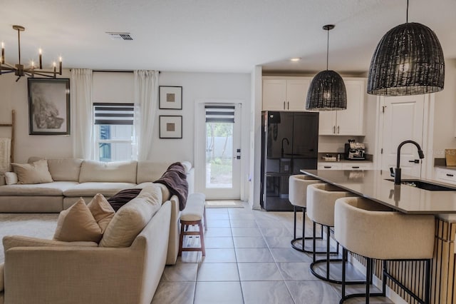 466 Cool Summer Ln, Davenport, FL 33837 - kitchen featuring open floor plan, a sink, freestanding refrigerator, a kitchen breakfast bar, and a chandelier