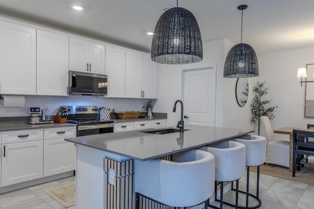 466 Cool Summer Ln, Davenport, FL 33837 - kitchen with stainless steel electric stove, a sink, a center island with sink, white cabinetry, and recessed lighting