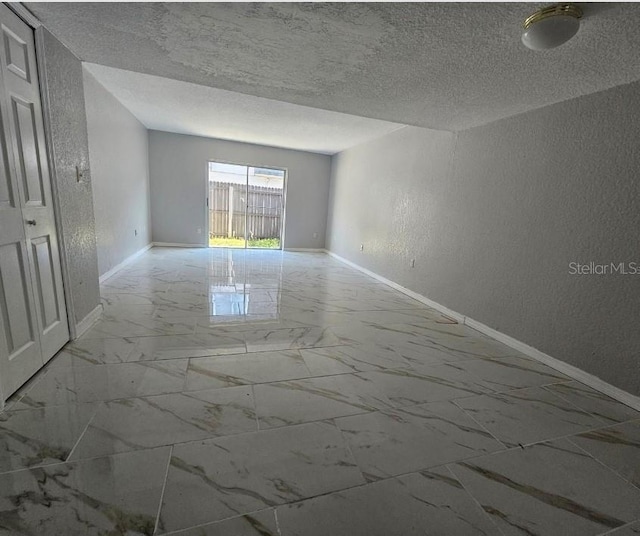 1920 Conway Rd Unit 4, Orlando, FL 32812 - unfurnished room with marble finish floors, a textured wall, baseboards, and a textured ceiling