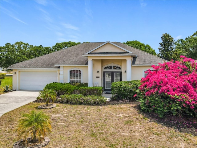 116 Westport Ln, Davenport, FL 33896 - neoclassical home featuring stucco siding, concrete driveway, and a garage