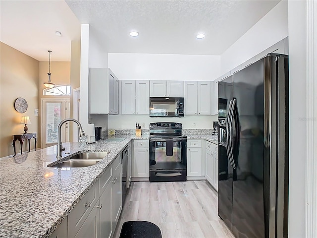 116 Westport Ln, Davenport, FL 33896 - kitchen featuring black appliances, a sink, light stone countertops, a peninsula, and recessed lighting