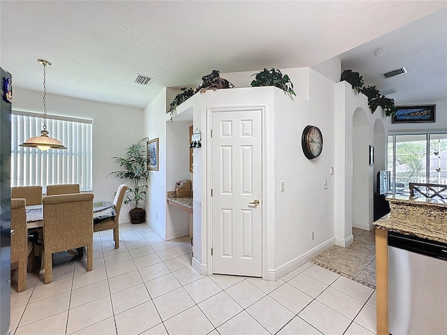 107 Amaca Ln, Davenport, FL 33897 - dining area featuring arched walkways, light tile patterned flooring, and a textured ceiling