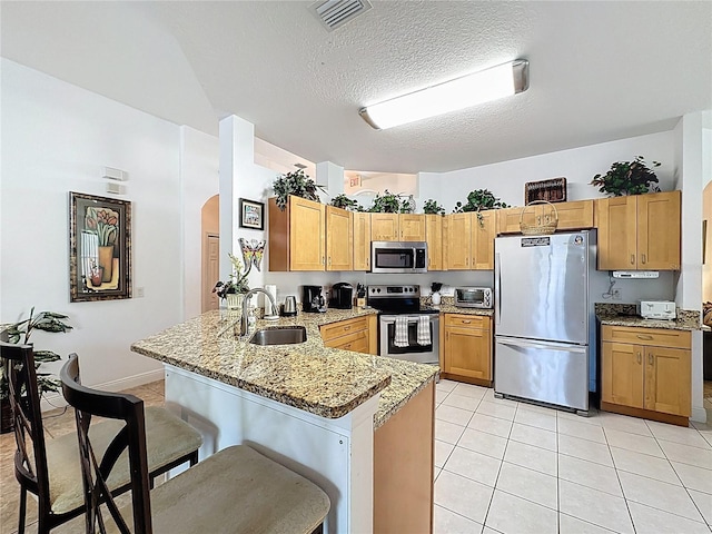 107 Amaca Ln, Davenport, FL 33897 - kitchen featuring appliances with stainless steel finishes, a peninsula, arched walkways, light stone countertops, and light tile patterned flooring