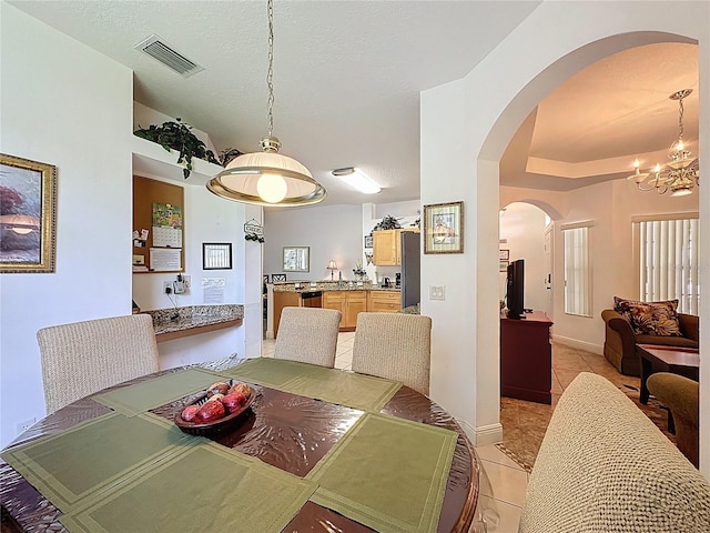 107 Amaca Ln, Davenport, FL 33897 - dining room featuring arched walkways, light tile patterned flooring, and a chandelier