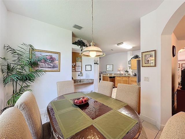 107 Amaca Ln, Davenport, FL 33897 - dining area with arched walkways, light tile patterned flooring, and a textured ceiling