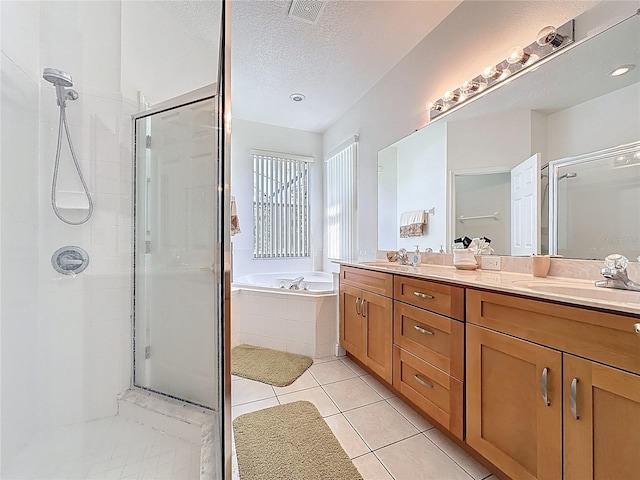 107 Amaca Ln, Davenport, FL 33897 - full bathroom featuring a shower stall, double vanity, a textured ceiling, a garden tub, and tile patterned floors