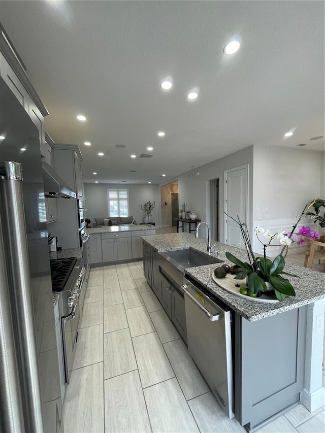 8919 Lakeshore Pointe Dr, Winter Garden, FL 34787 - kitchen with appliances with stainless steel finishes, gray cabinets, under cabinet range hood, recessed lighting, and a spacious island