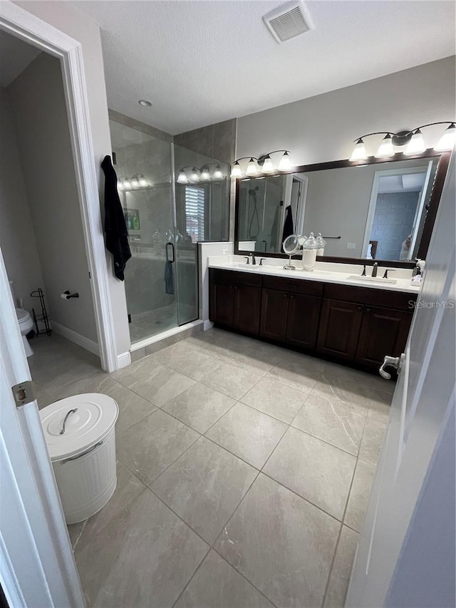 8919 Lakeshore Pointe Dr, Winter Garden, FL 34787 - full bathroom with a stall shower, double vanity, a textured ceiling, and tile patterned flooring
