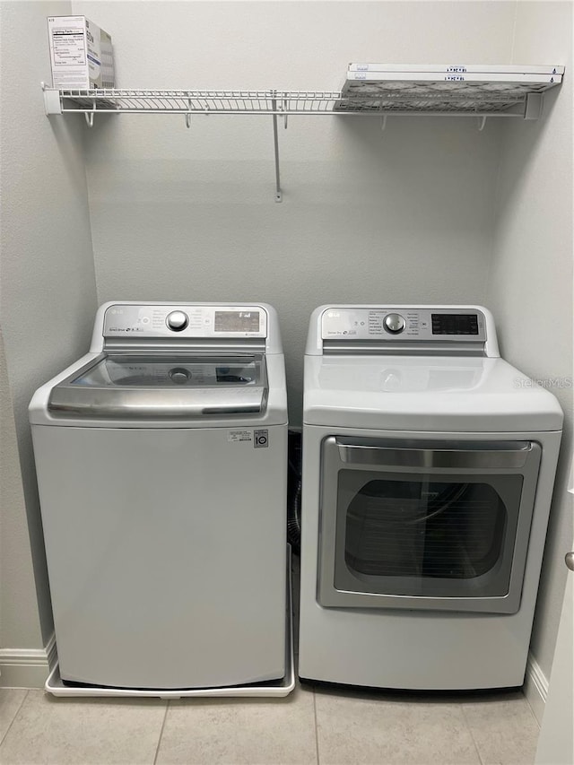 8919 Lakeshore Pointe Dr, Winter Garden, FL 34787 - laundry room featuring washing machine and dryer and light tile patterned flooring