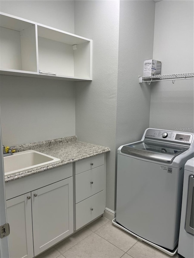 8919 Lakeshore Pointe Dr, Winter Garden, FL 34787 - laundry room featuring washing machine and clothes dryer, light tile patterned flooring, and cabinet space