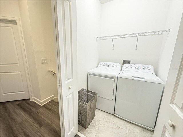 4736 Tribute Trl, Kissimmee, FL 34746 - laundry area featuring washer and dryer, baseboards, and light wood finished floors