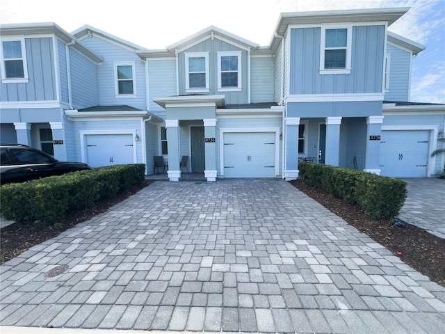 4736 Tribute Trl, Kissimmee, FL 34746 - view of property featuring decorative driveway, board and batten siding, and an attached garage