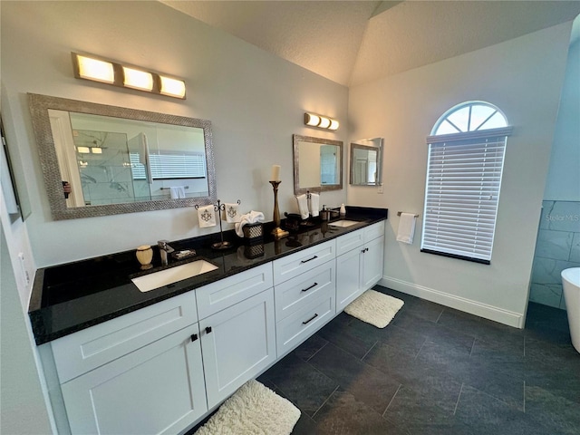 2356 Chadwick Cir, Kissimmee, FL 34746 - full bathroom with lofted ceiling, double vanity, tiled shower, a freestanding bath, and baseboards