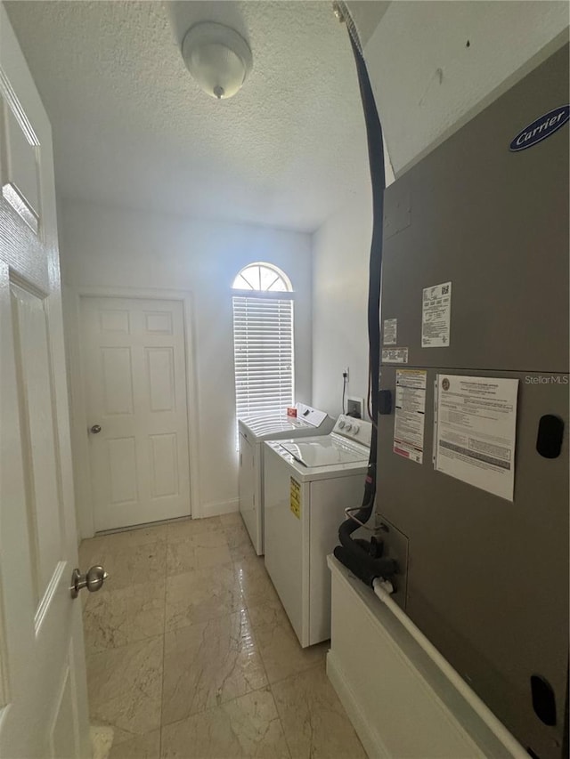 2356 Chadwick Cir, Kissimmee, FL 34746 - washroom with heating unit, independent washer and dryer, light marble finish flooring, a textured ceiling, and baseboards