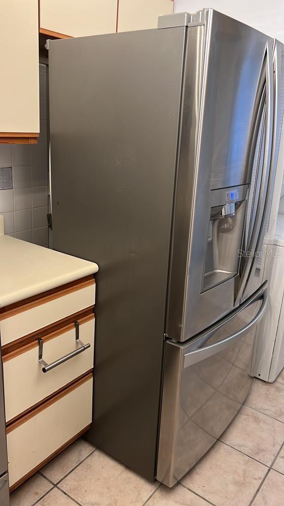 2900 S Semoran Blvd Unit 1, Orlando, FL 32822 - kitchen view of stainless steel fridge with ice dispenser, light countertops, and white cabinetry