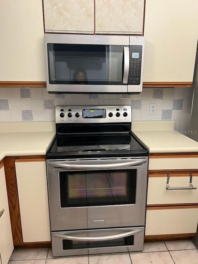 2900 S Semoran Blvd Unit 1, Orlando, FL 32822 - kitchen with appliances with stainless steel finishes, light countertops, tasteful backsplash, and light tile patterned floors
