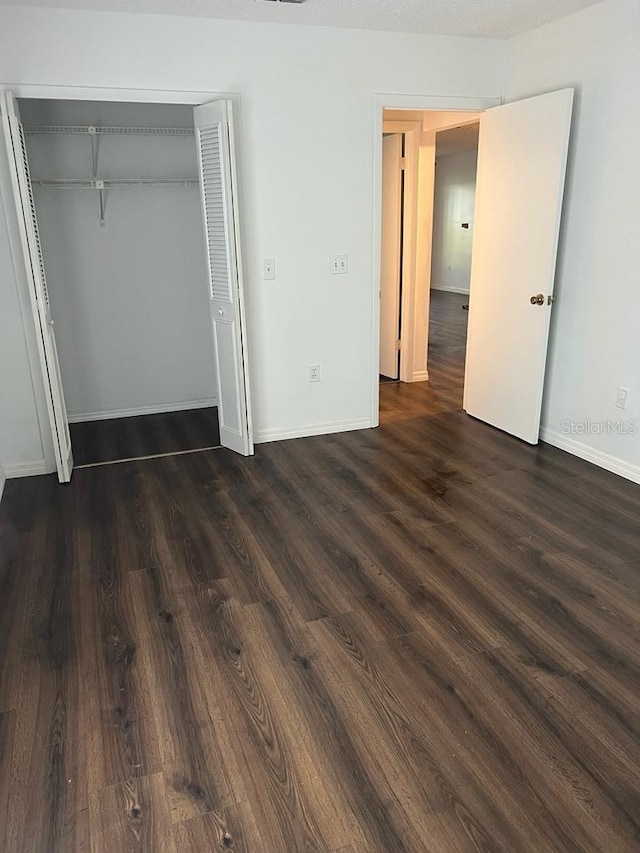 2900 S Semoran Blvd Unit 1, Orlando, FL 32822 - unfurnished bedroom featuring dark wood-style flooring, baseboards, and a closet