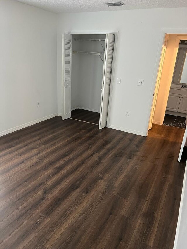2900 S Semoran Blvd Unit 1, Orlando, FL 32822 - unfurnished bedroom featuring dark wood-style flooring, a closet, and baseboards