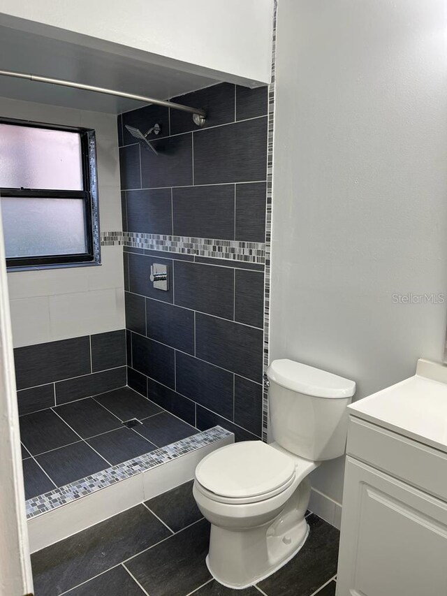 2900 S Semoran Blvd Unit 1, Orlando, FL 32822 - bathroom with a tile shower, toilet, tile patterned flooring, and vanity