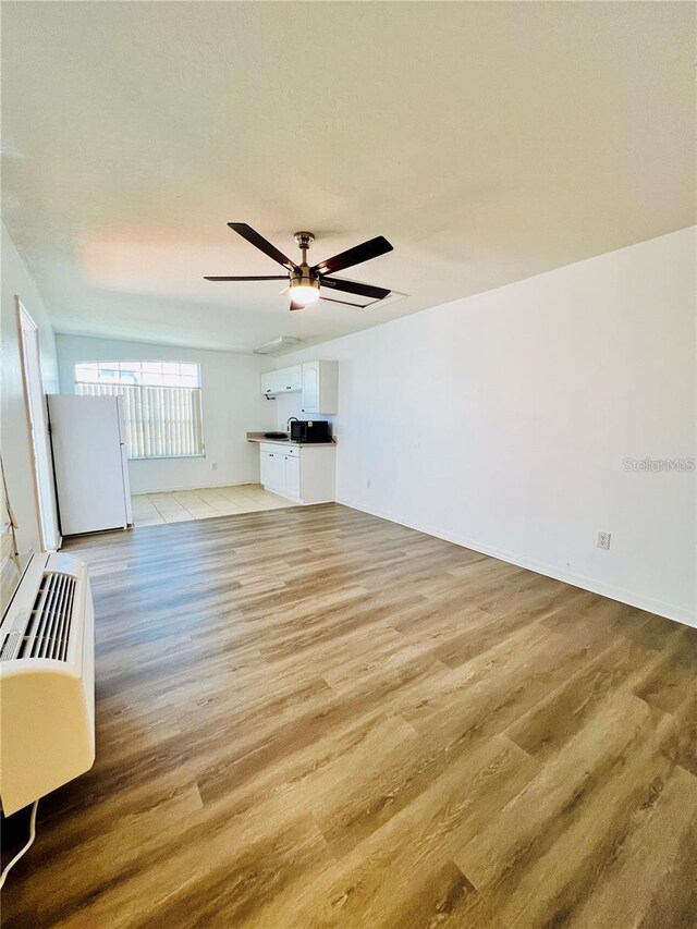 658 Caribbean Dr, Davenport, FL 33897 - unfurnished living room featuring ceiling fan and light wood finished floors