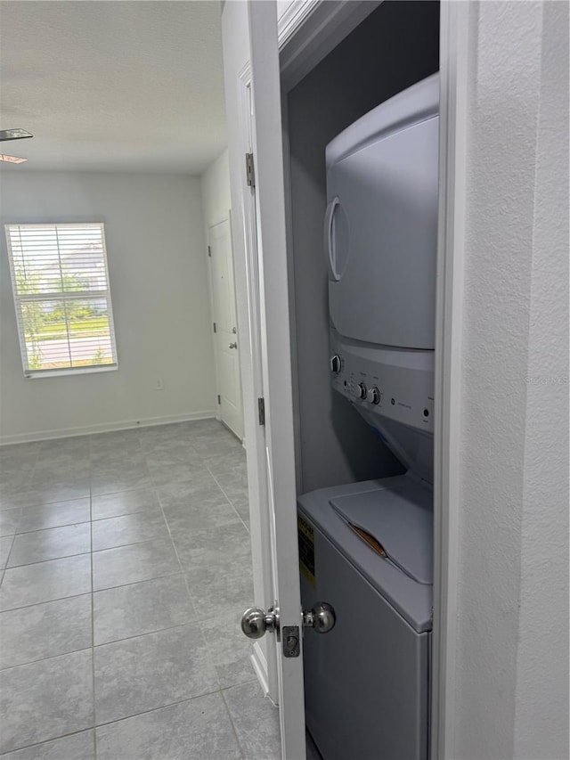 553 SE Turtle, Haines City, FL 33844 - washroom with stacked washing machine and dryer and tile patterned flooring
