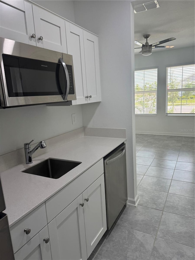 553 SE Turtle, Haines City, FL 33844 - kitchen featuring stainless steel appliances, ceiling fan, light tile patterned flooring, white cabinets, and light countertops