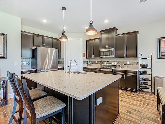 605 San Augusto Dr, Kissimmee, FL 34759 - kitchen featuring stainless steel appliances, tasteful backsplash, light wood-style flooring, decorative light fixtures, and recessed lighting