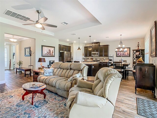 605 San Augusto Dr, Kissimmee, FL 34759 - living area with light wood-style floors, a ceiling fan, a chandelier, a raised ceiling, and recessed lighting