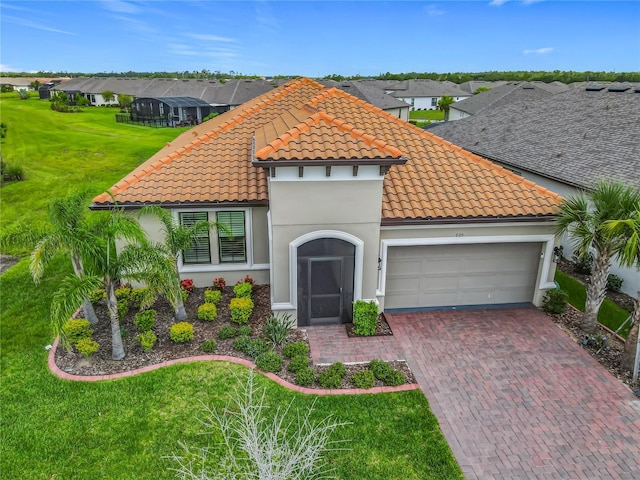 605 San Augusto Dr, Kissimmee, FL 34759 - mediterranean / spanish-style home with a tile roof, a garage, decorative driveway, stucco siding, and a front lawn