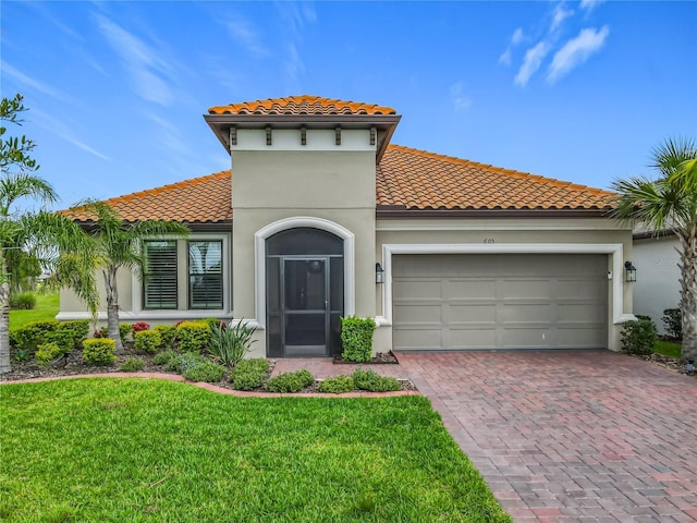605 San Augusto Dr, Kissimmee, FL 34759 - mediterranean / spanish-style home with a tiled roof, decorative driveway, a garage, and a front lawn