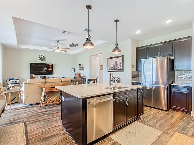 605 San Augusto Dr, Kissimmee, FL 34759 - kitchen with stainless steel appliances, a tray ceiling, wood tiled floors, decorative light fixtures, and ceiling fan