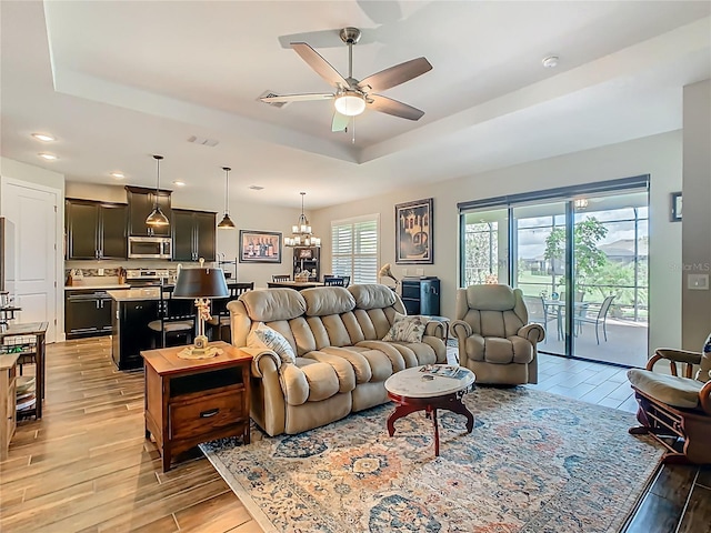 605 San Augusto Dr, Kissimmee, FL 34759 - living area featuring ceiling fan, light wood-style flooring, a tray ceiling, a chandelier, and recessed lighting