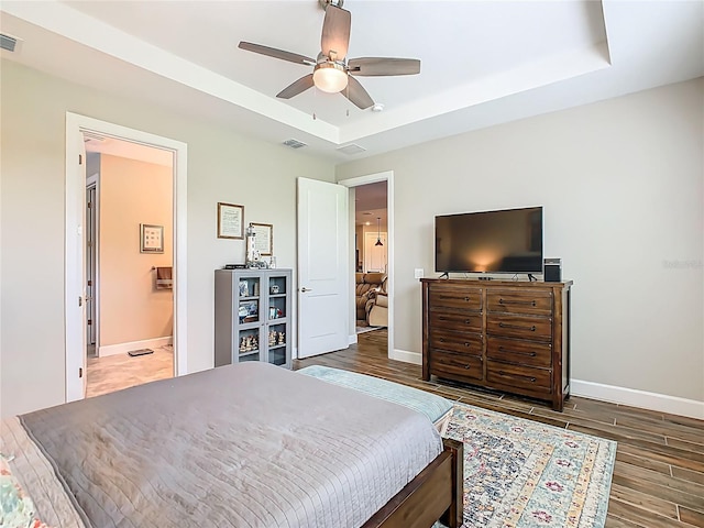 605 San Augusto Dr, Kissimmee, FL 34759 - bedroom with wood finished floors, a raised ceiling, ceiling fan, and ensuite bathroom