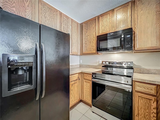 10746 Regent Square Dr Unit 1502, Orlando, FL 32825 - kitchen with black appliances, light tile patterned floors, light countertops, and a textured ceiling