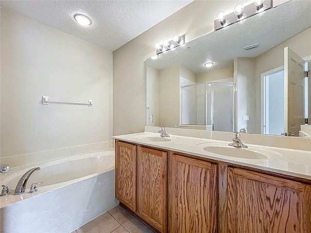 10746 Regent Square Dr Unit 1502, Orlando, FL 32825 - bathroom with double vanity, a bath, a textured ceiling, a shower stall, and tile patterned flooring