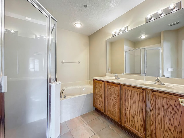 10746 Regent Square Dr Unit 1502, Orlando, FL 32825 - bathroom featuring a shower stall, double vanity, a garden tub, tile patterned floors, and a textured ceiling