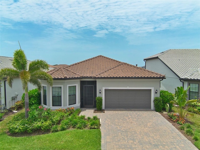 14553 Eagle Branch Dr, Nokomis, FL 34275 - mediterranean / spanish-style house with a garage, decorative driveway, stucco siding, and a tiled roof