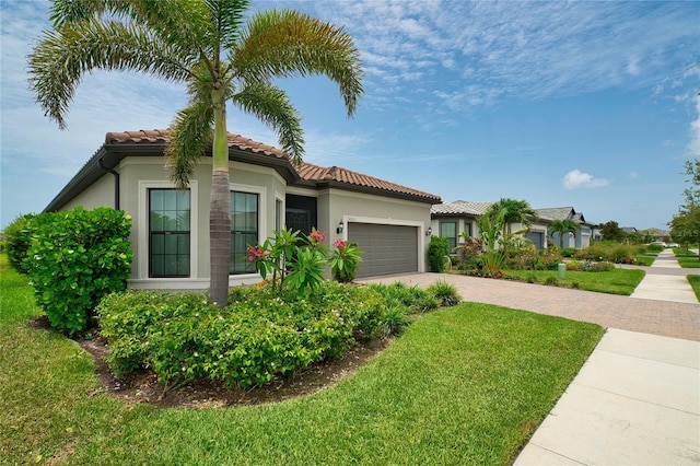 14553 Eagle Branch Dr, Nokomis, FL 34275 - mediterranean / spanish home featuring decorative driveway, a garage, a front yard, a tile roof, and stucco siding