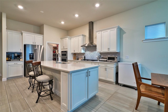 14553 Eagle Branch Dr, Nokomis, FL 34275 - kitchen with wall chimney exhaust hood, backsplash, a kitchen breakfast bar, white cabinets, and a center island with sink
