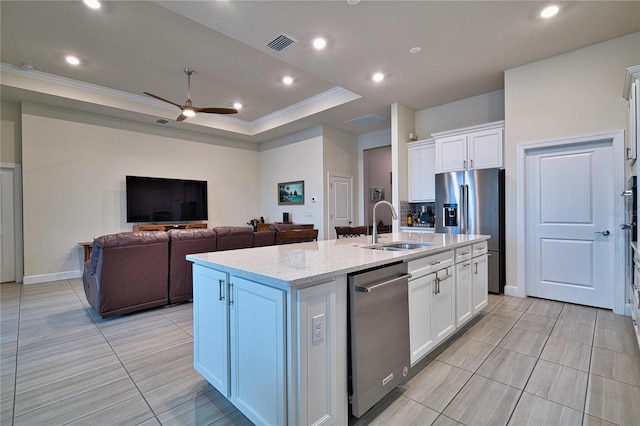 14553 Eagle Branch Dr, Nokomis, FL 34275 - kitchen with a sink, appliances with stainless steel finishes, an island with sink, white cabinetry, and ornamental molding