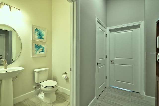 14553 Eagle Branch Dr, Nokomis, FL 34275 - half bathroom with tile patterned flooring, toilet, baseboards, and a sink