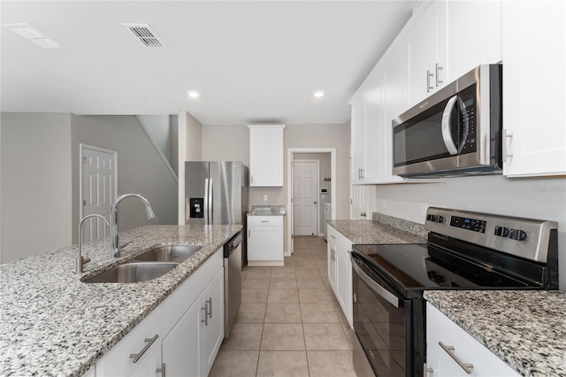 5288 Stephs Field St, Saint Cloud, FL 34771 - kitchen with appliances with stainless steel finishes, a sink, white cabinets, recessed lighting, and light stone counters