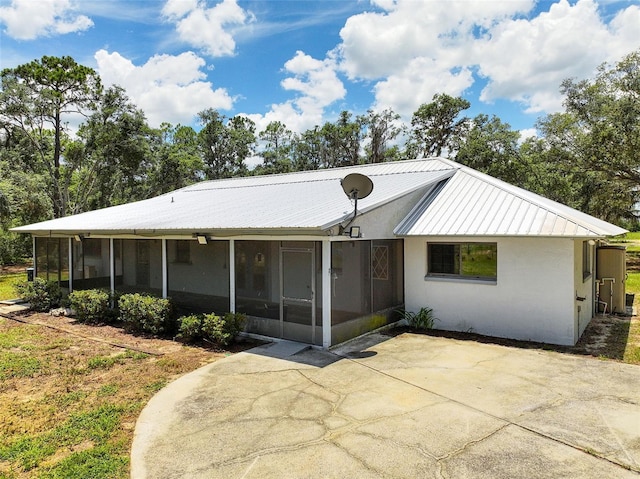 11323 Kijik Trl, Groveland, FL 34736 - back of house featuring a sunroom, a patio, a metal roof, and stucco siding
