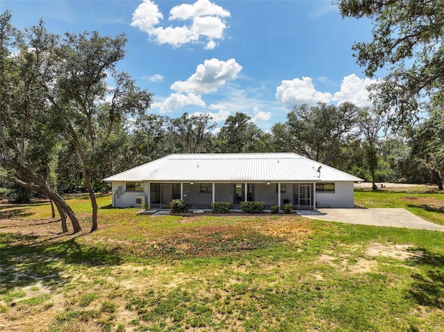 11323 Kijik Trl, Groveland, FL 34736 - rear view of property featuring a lawn, a metal roof, covered porch, and view of wooded area