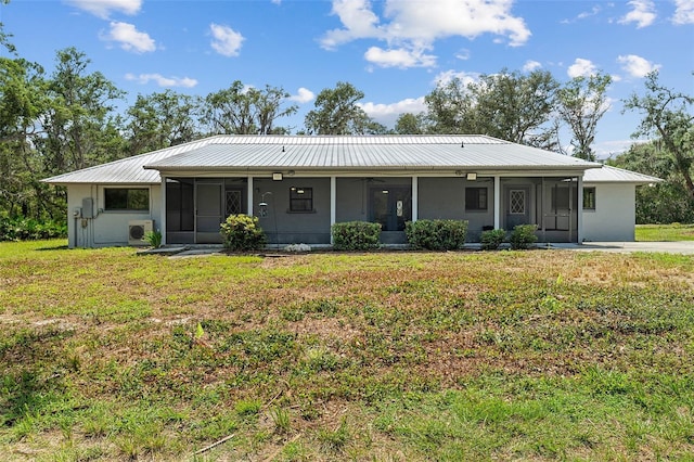 11323 Kijik Trl, Groveland, FL 34736 - view of front of home with a sunroom, a front yard, and a metal roof