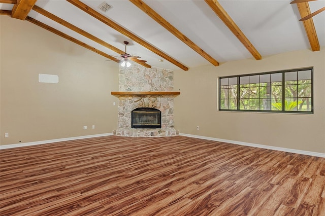 11323 Kijik Trl, Groveland, FL 34736 - unfurnished living room with beamed ceiling, wood finished floors, ceiling fan, a stone fireplace, and high vaulted ceiling