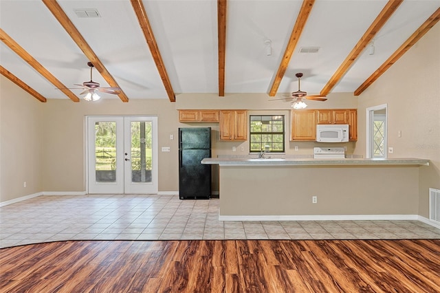 11323 Kijik Trl, Groveland, FL 34736 - kitchen with white microwave, a ceiling fan, freestanding refrigerator, light countertops, and stove