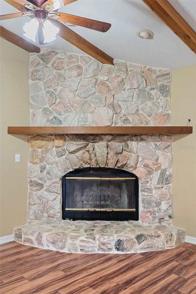 11323 Kijik Trl, Groveland, FL 34736 - detailed view of a stone fireplace, a ceiling fan, wood finished floors, and beamed ceiling