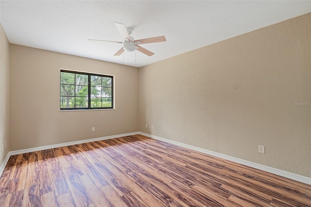 11323 Kijik Trl, Groveland, FL 34736 - empty room with wood finished floors, ceiling fan, a textured wall, and a textured ceiling